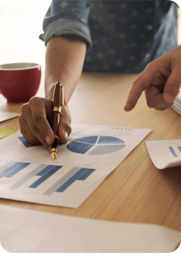 Business professionals reviewing marketing charts and data reports during a planning meeting in a Malaysian digital marketing and web design agency.