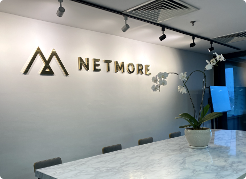 Elegant meeting area with Netmore logo and orchid plant, representing a modern and inspiring career space in Malaysia.