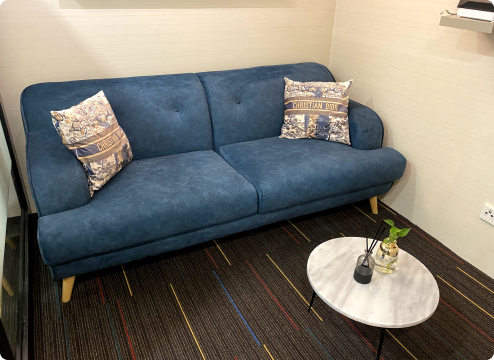 Comfortable lounge area with blue sofa and marble coffee table in Netmore office, reflecting a relaxing and balanced career workspace in Malaysia.