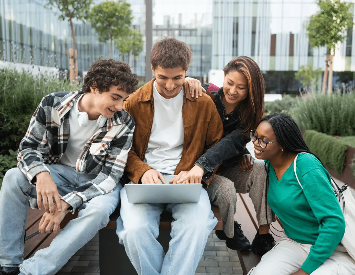 Group of young marketers collaborating on laptop outdoors, representing Netmore’s creative social media and digital marketing agency in Malaysia.