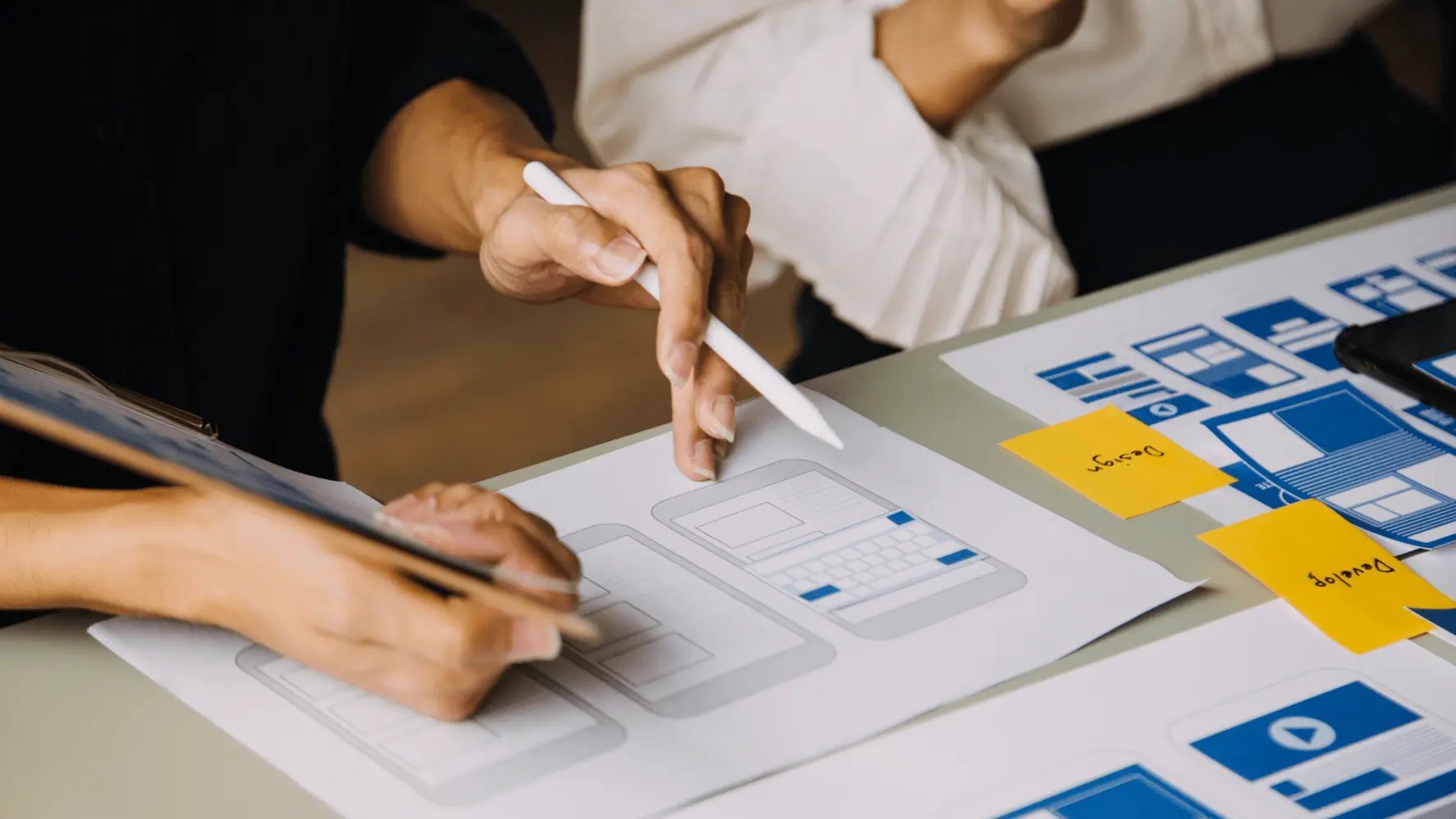 Close-up of designers working on mobile wireframes as part of the effective web design process.