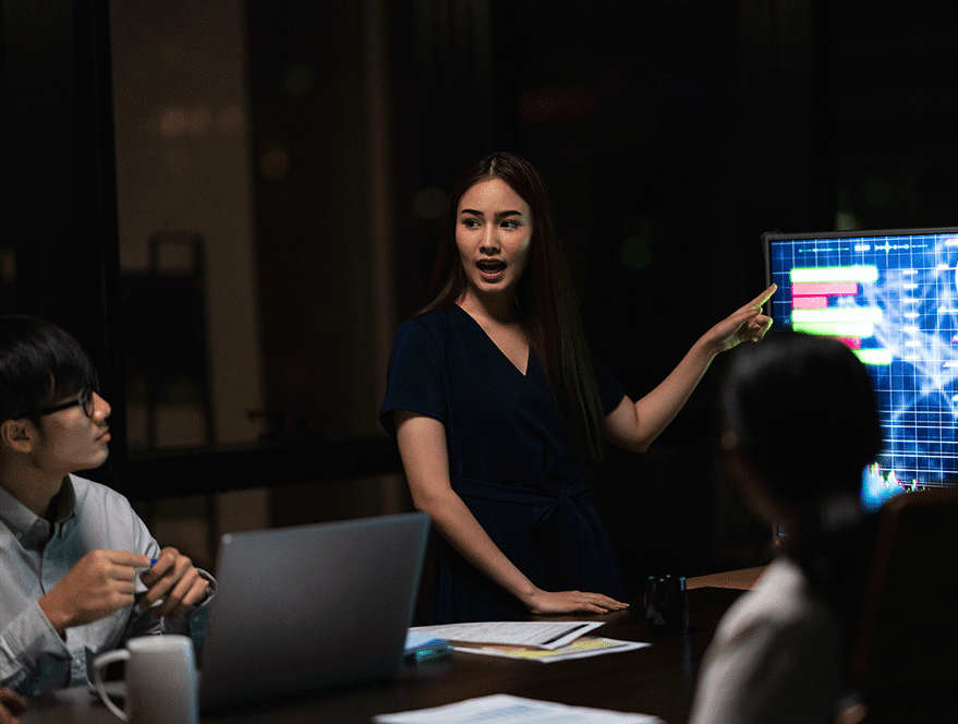 Female presenter explaining website design strategy during team meeting. Professional web design Malaysia.
